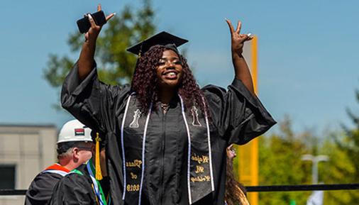 Graduate smiling and crossing the stage